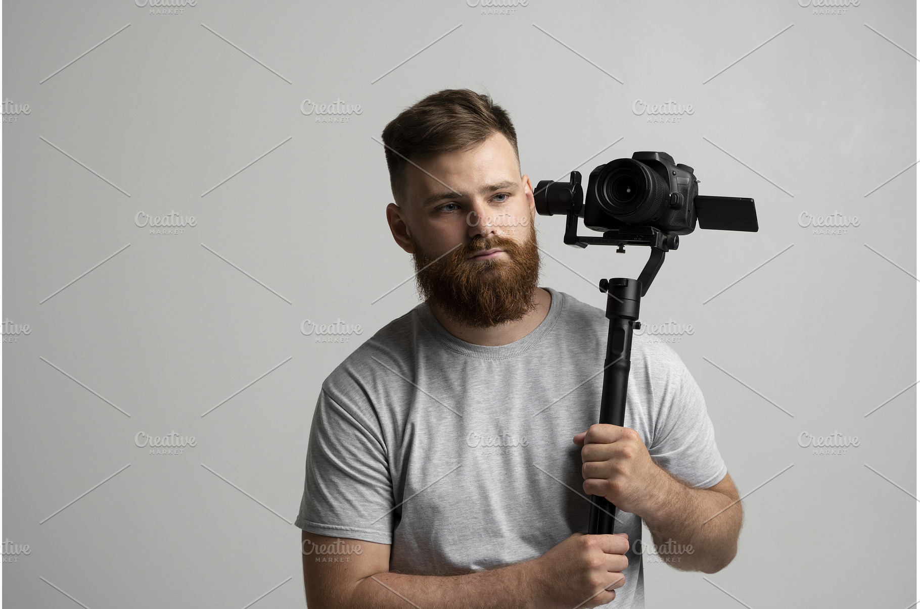 Bearded videographer holding camera, an Industrial Photo by volodymyrshtun13795