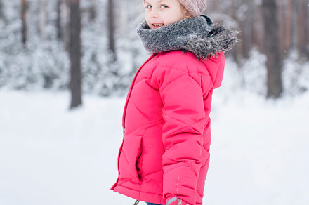 Little girl in a bright jacket plays in the winter forest, a Person Photo by Olena Rudo