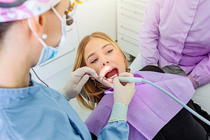 Dentist using dental tools while examining patient's teeth in de, a Health & Medical Photo by Antonio Gravante Market