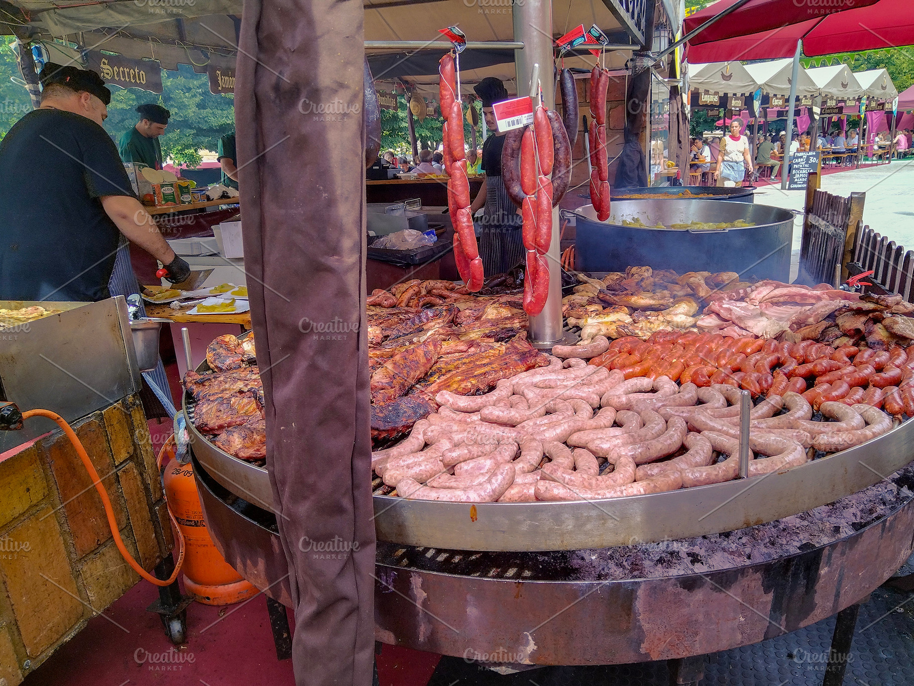 Street grill with sausages at outdoor food market, a Food & Drink Photo by DanFLCreativo
