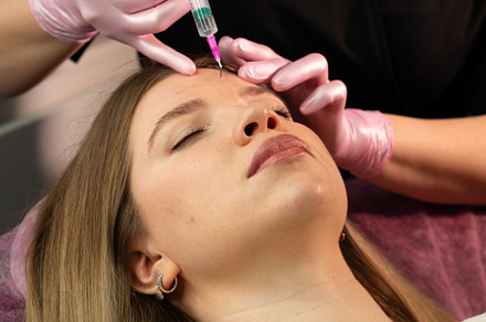 Practitioner apply patient’s forehea