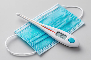 Thermometer on surgical mask for health safety, a Health & Medical Photo by AlyaAnd