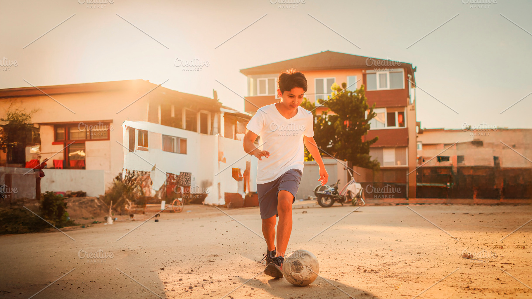 Teenager playing soccer in neighborhood street, a Person Photo by DanFLCreativo