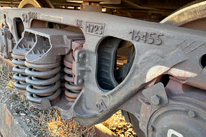 Close-up of a train wheel assembly showcasing springs and metal components, an Industrial Photo by Textures & Backgrounds