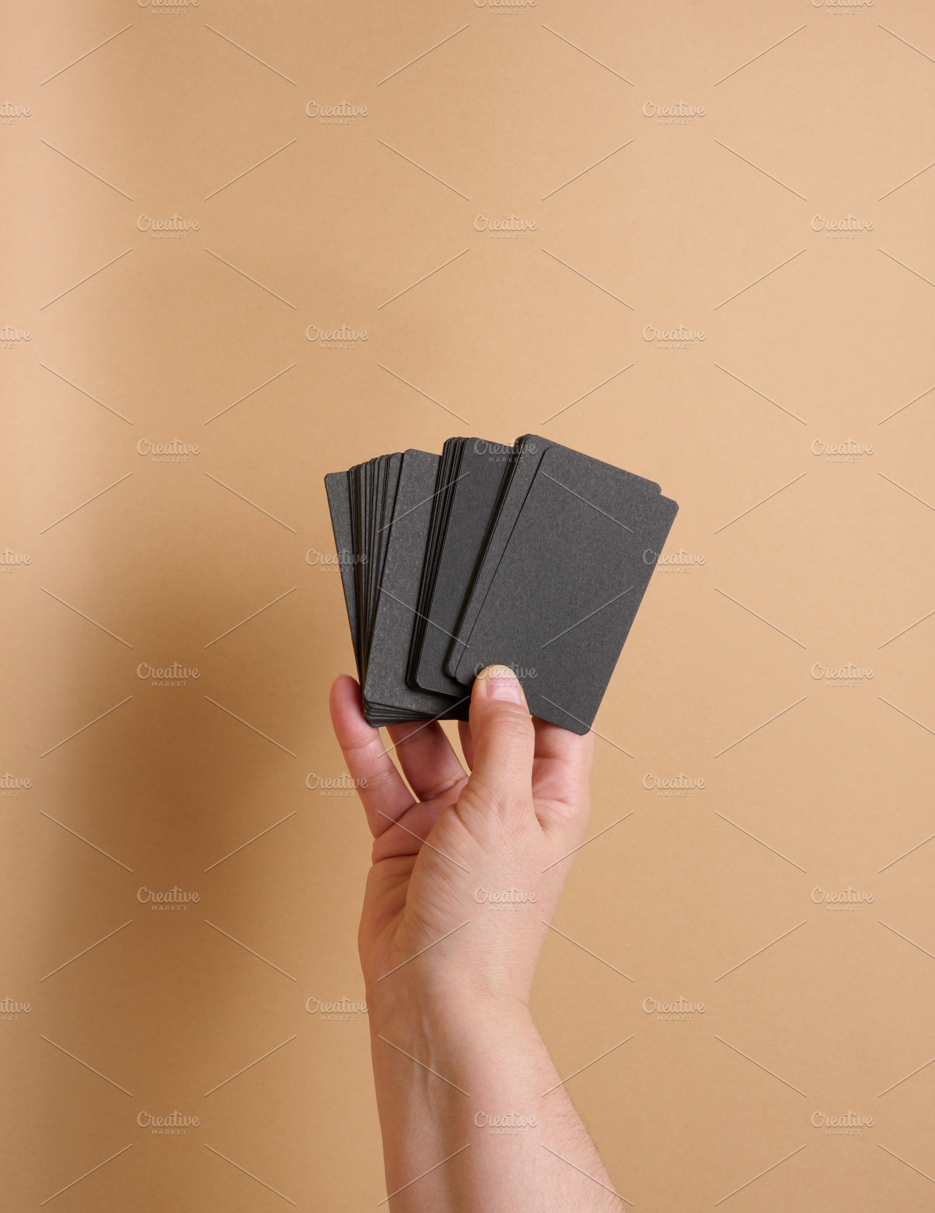 A woman's hand holds a stack of blank black paper business cards, a Business Photo by ndanko