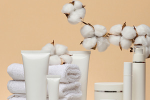 Various white cosmetics, a stack of towels and a cotton branch o, a Beauty & Fashion Photo by ndanko