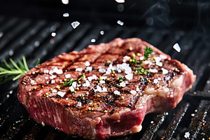 Juicy steak grilling with herbs and spices elevated by falling seasoning, a Food & Drink Photo by AlyaAnd