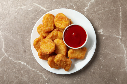 Plate with fried chicken nuggets and ketchup on gray table, top, a Food & Drink Photo by AtlasStudio PRO