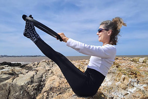 Woman practices pilates on a rugged rocky surface, a Sports & Recreation Photo by DanFLCreativo