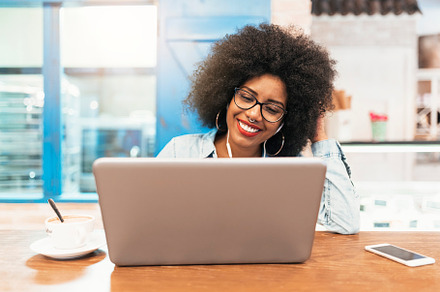 Afro woman using mobile and laptop stock photo containing woman and black, a Person Photo by nunezimage