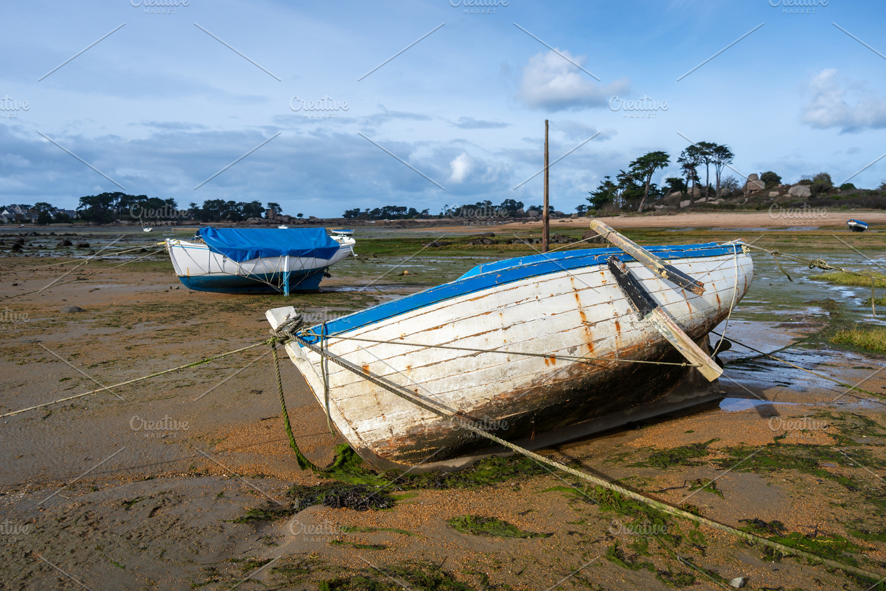 Old weathered boat beached on tidal flats in Tregastel, France, a Transportation Photo by GoodGoods