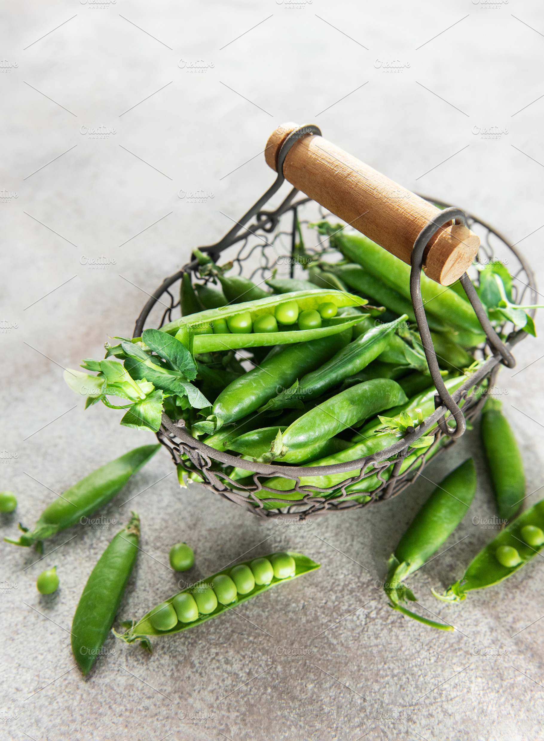 Fresh green peas pods in metal basket harvesting concept, a Food & Drink Photo by Olena Rudo
