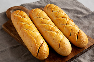 Homemade French Baguette with Garlic Filling on a wooden board,, a Food & Drink Photo by LiudmylaChuhunova