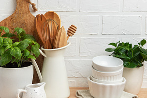 Kitchen utensils and plants creating cozy atmosphere on wooden c, a Food & Drink Photo by Olena Rudo