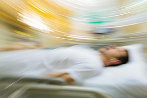 Patient lying on a hospital bed with, a Photo by Tanuart