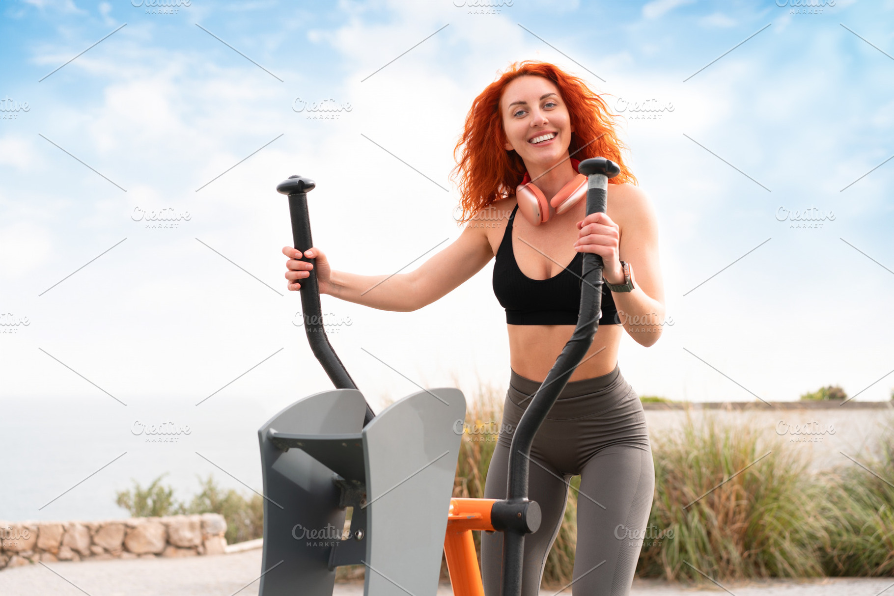 Cheerful sporty woman exercising on stepper machine at outdoor gym, a Person Photo by andreonegin market
