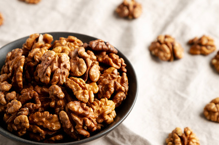 Raw Walnut Halfs in a Bowl, side view.
