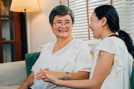 Asian mother and daughter holding hands and laughing