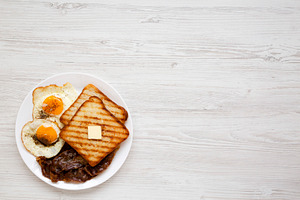 Homemade Healthy Sunnyside Eggs Breakfast on a white plate on a, a Food & Drink Photo by LiudmylaChuhunova