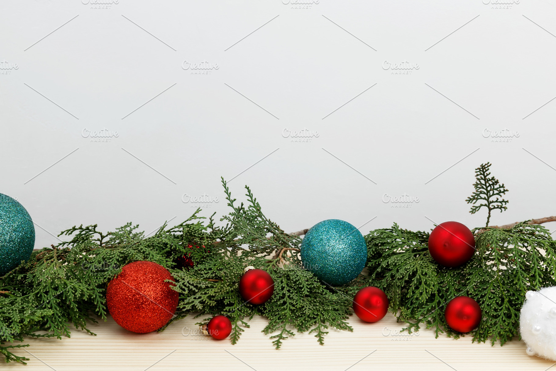 Creating a festive atmosphere, thuja branches and Christmas ornaments on a wood, a Photo by matucha