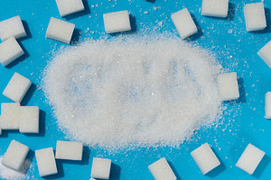 Scattered white granulated sugar surrounded by refined sugar cub, a Food & Drink Photo by ndanko