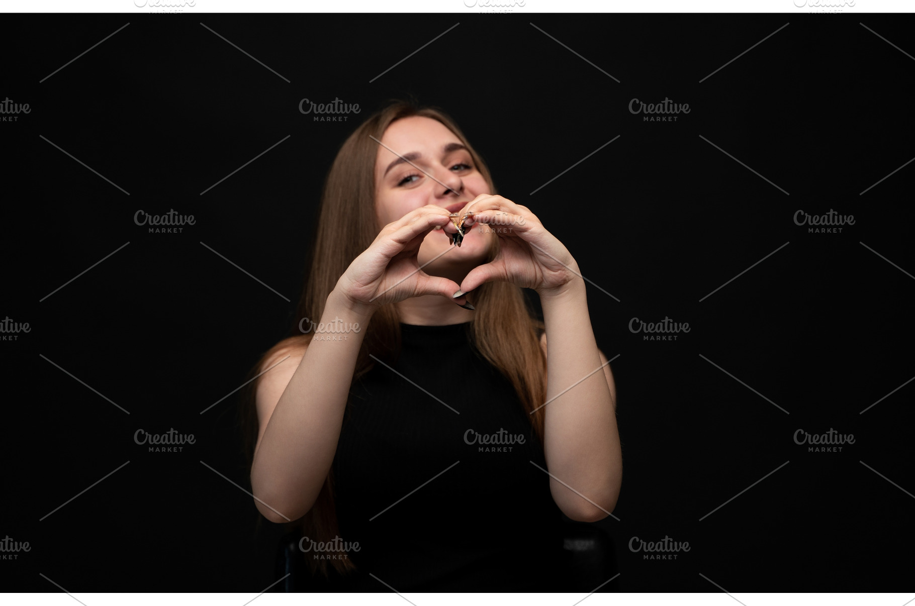 Young woman forming heart shape with, a Person Photo by volodymyrshtun13795