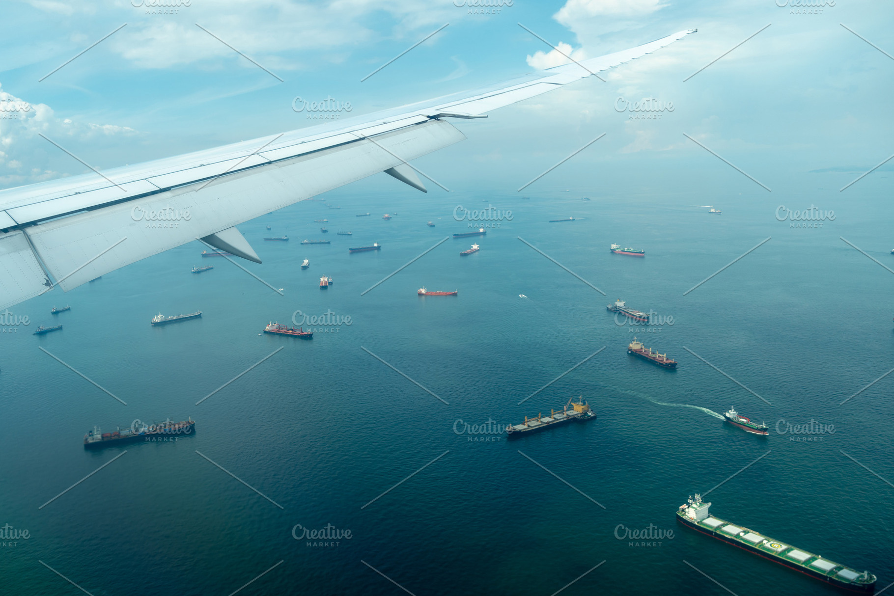 Airplane arriving over sea with cargo ships in Singapore, a Transportation Photo by GoodGoods