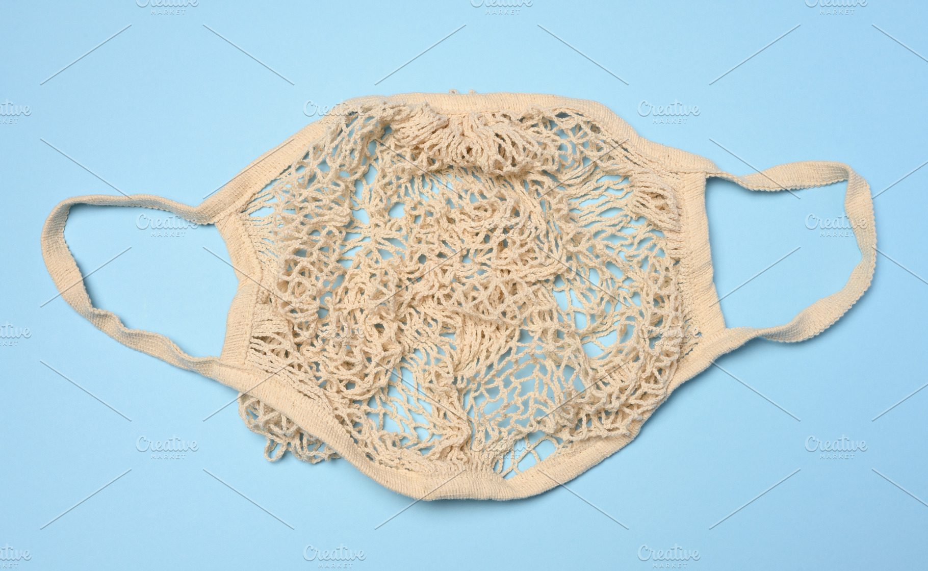 A beige handmade mesh shopping bag on a blue background. Eco-sho, a Background Photo by ndanko