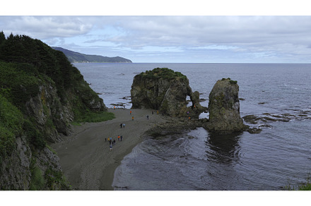 People on shore with rocks and arch, a Nature Photo by Media Whale Stock