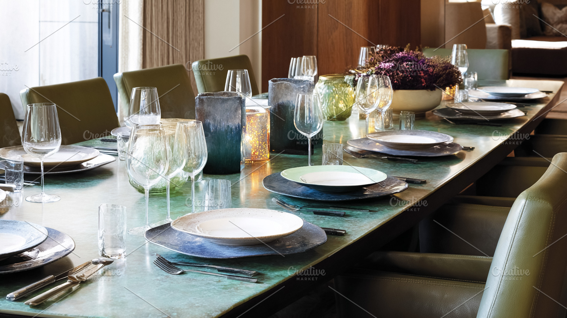 Long dining table elegantly set with plates, glasses, silverware, a Photo by Studio ANNA