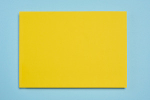 Blank yellow sheet of paper on blue background, abstract backdro, a Background Photo by ndanko
