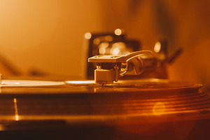 Close up of turntable needle on a vi featuring 70s, 80s, and album