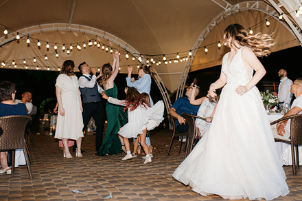 bride in a white dress throws a wedding bouquet