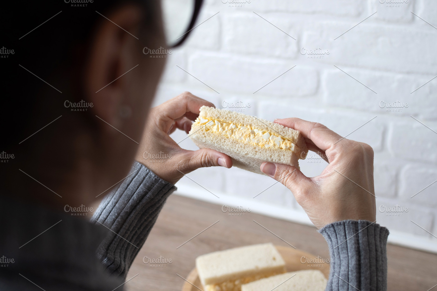 Woman taking a tamago Sando sandwich, a Photo by etorres69