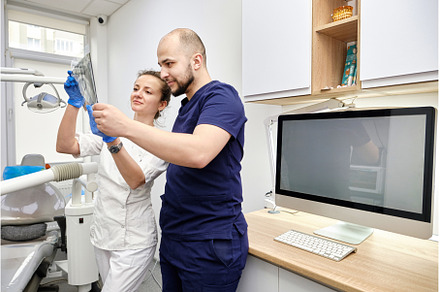 Male and Female Dentists Reviewing X