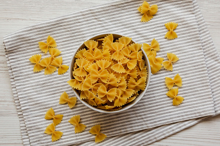 Dry Organic Farfalle Pasta in a Bowl on a white wooden backgroun, a Food & Drink Photo by LiudmylaChuhunova