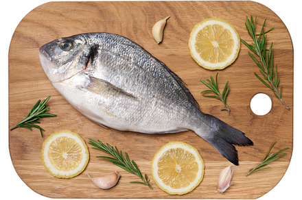 Raw whole dorado fish on wooden kitchen board and spices for coo, a Food & Drink Photo by ndanko