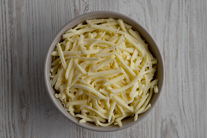 Shredded Mozzarella Cheese in a Bowl, top view. Overhead, from a, a Food & Drink Photo by LiudmylaChuhunova