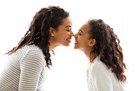 Mom and daughter touching each other with noses, a Background Photo by Prostock-Studio