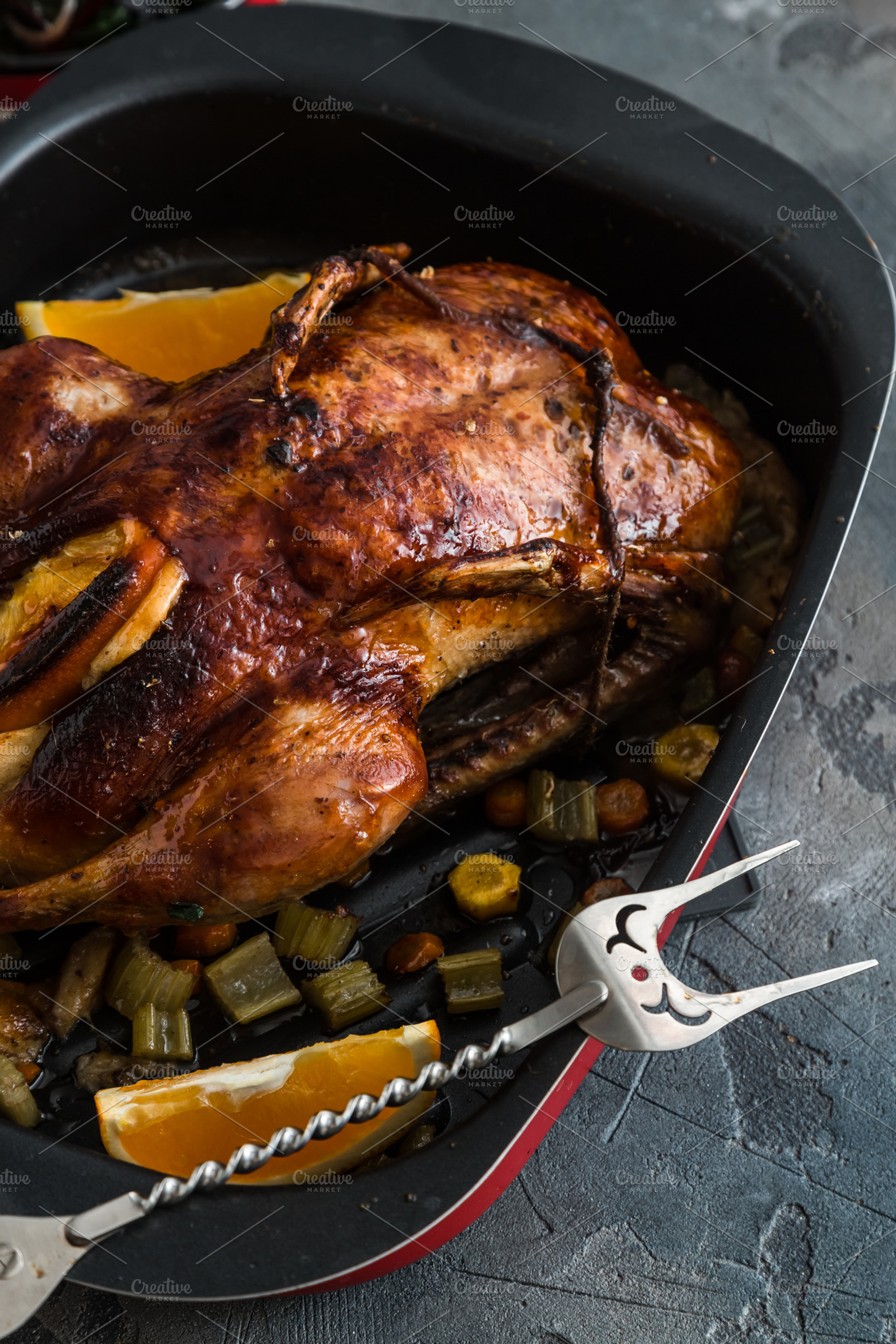 Roast duck and oranges on a black slate board, close view, a Food & Drink Photo by Konstantin K.