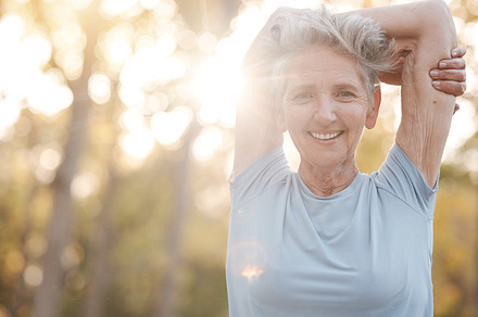 Fitness, nature and senior woman stretching before an outdoor run or cardio workout with bokeh. Happy, smile and portrait of elderly lady doing warm up exercise before training for a race or marathon, a Photo by Peopleimages.com
