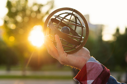 Hand holding antique metal globe