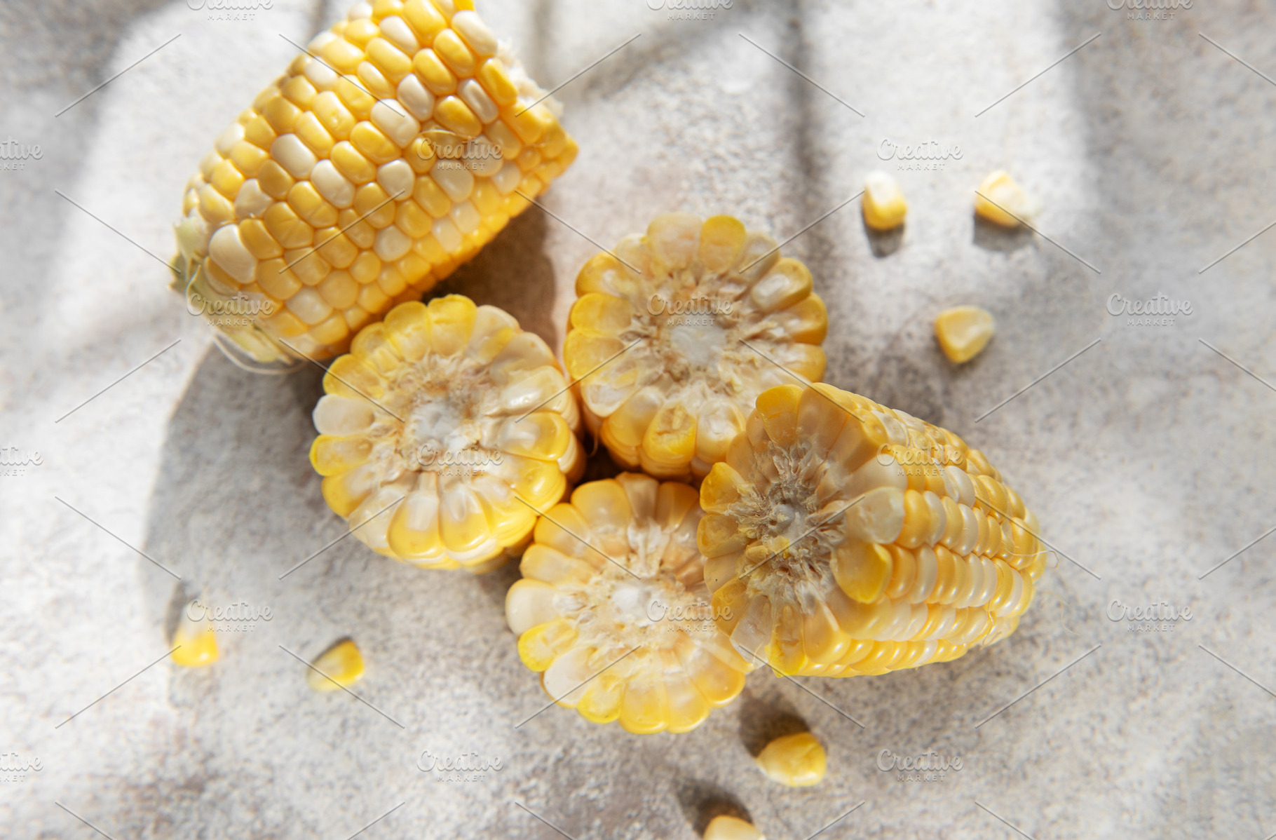 Fresh corn cobs with kernels on gray background, a Food & Drink Photo by Olena Rudo