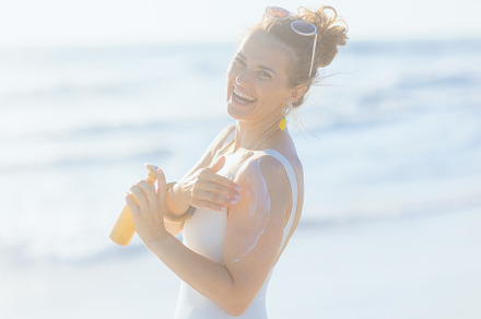 Portrait of happy elegant woman in white beachwear at beach, a Person Photo by Alliance Images