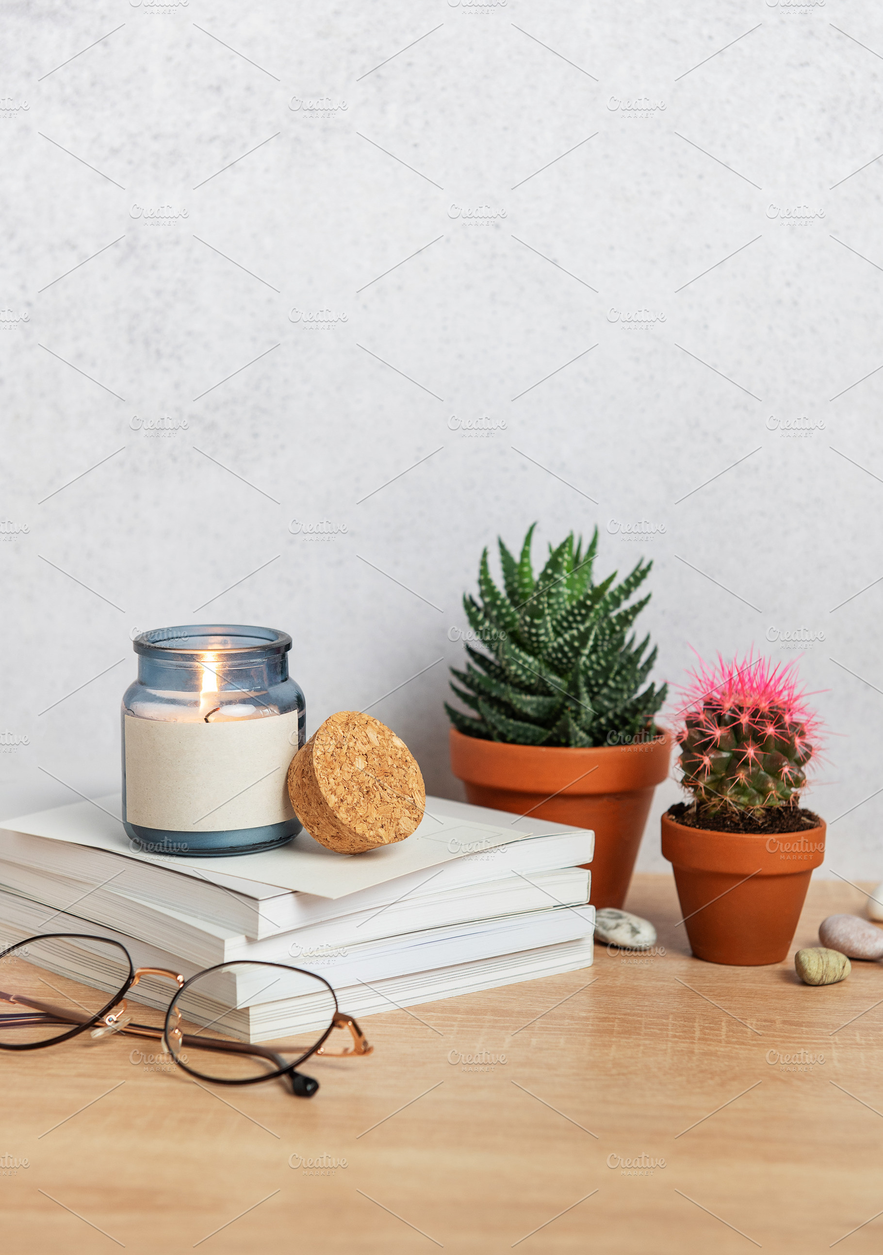 Burning scented candle, books, eyeglasses, and potted plants cre, a Nature Photo by Olena Rudo