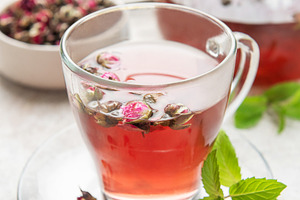 Rose bud tea infusion in glass mug on table, a Food & Drink Photo by Olena Rudo