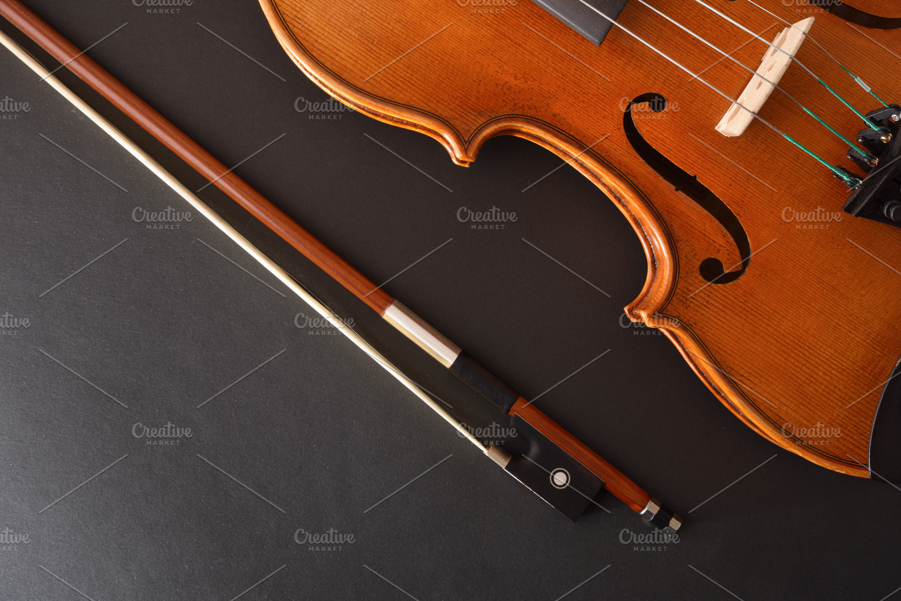 Traditional stringed violin and bow placed diagonally on black b, an Arts & Entertainment Photo by Davizro's Market