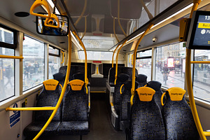 Bus interior with yellow priority seats and bright handrails in a modern urban, a Photo by AS photostudio