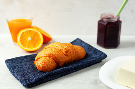 Delicious croissant resting on blue napkin with orange juice, jam and butter fo, a Food & Drink Photo by Antonio Gravante Market