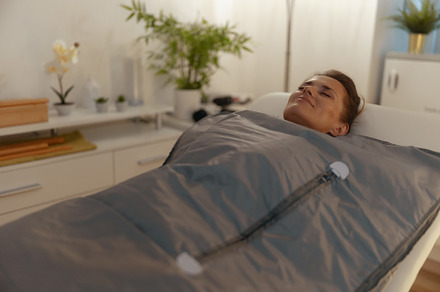 woman doing whiskey swaddling procedure in thermal blanket, a Health & Medical Photo by Alliance Images